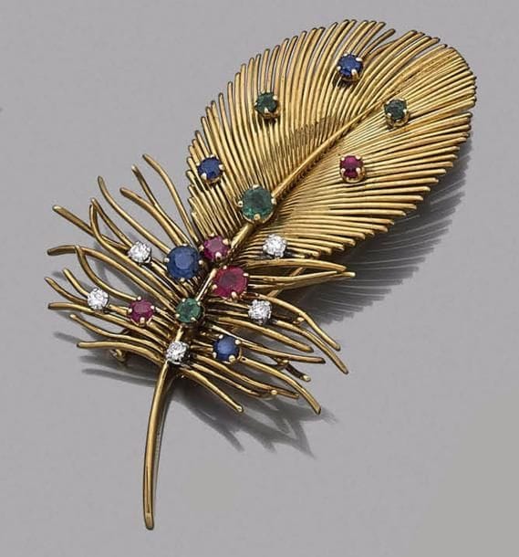 BOUCHERON
Broche-clip plume en fils d’or 18K (750‰), piquée de saphirs, émeraudes, diamants et rubis. Signée. Dans son écrin.
Hauteur : 6,5 cm environ. Poids brut : 22,4 g