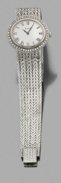 PIAGET
Montre de dame en or gris 18K (750‰), cadran ovale serti de diamants, fond guilloché, index chiffres romains, bracelet ruban souple en or tissé, mouvement mécanique. Numérotée. 
Longueur : 16,5 cm environ. Poids brut : 50,1 g