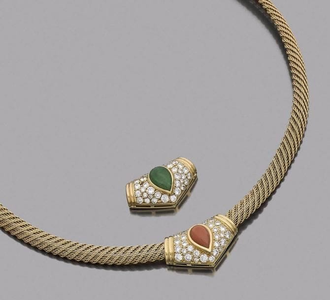 Collier ruban tressé en or 18K (750‰), orné d’un motif amovible en or 18K pavé de diamants, centré d’un cabochon de corail en forme de goutte.
Longueur : 40,5 cm environ. Poids brut : 34,8 g
(on joint un second motif serti d’une chrysoprase)