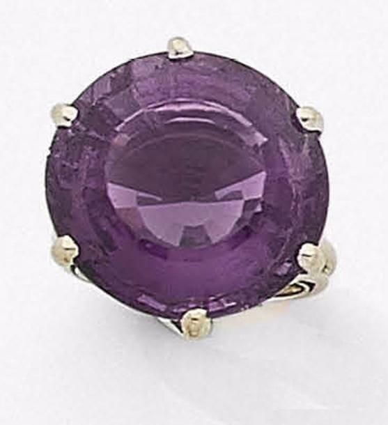 Bague en fils d’or gris 18K (750‰), ornée d’une améthyste ronde.
Travail français des années 1960.
Tour de doigt : 53. Poids brut : 15,8 g