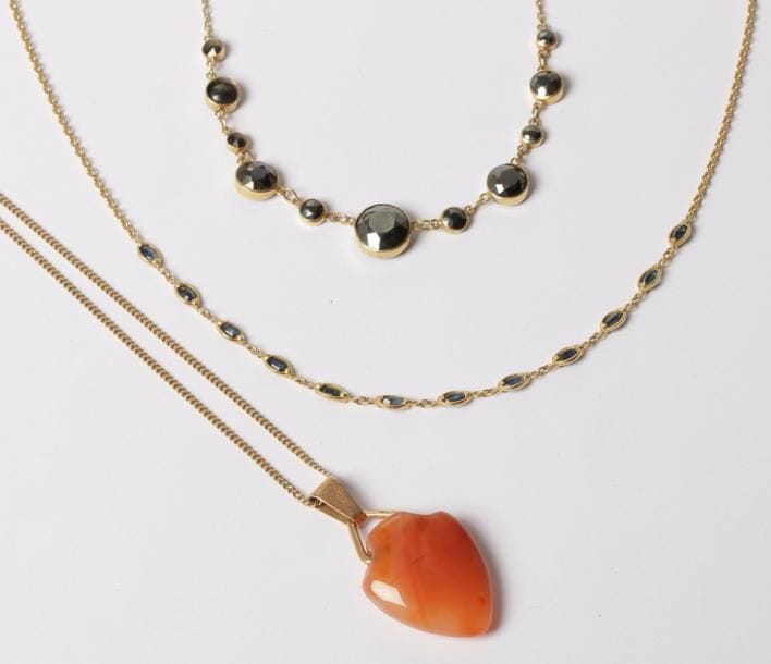 Lot de 3 colliers en or 18K (750‰) : l’un orné de saphirs, l’autre serti de pyrites, le dernier retenant un pendentif cordiforme en cornaline.
Poids brut : 25,7 g
