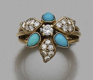 Bague en fils d’or jaune 18K (750‰), formant une fleur stylisée, ornée de diamants pavés et de turquoises cabochons.
Travail français.
Tour de doigt : 48. Poids brut : 7,5 g