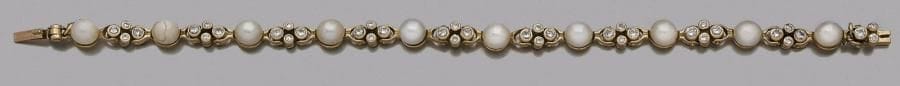 Bracelet en or 18K (750‰), ponctué de perles de culture scandées de maillons sertis de diamants.
Longueur : 17,2 cm environ. Poids brut : 14,8 g