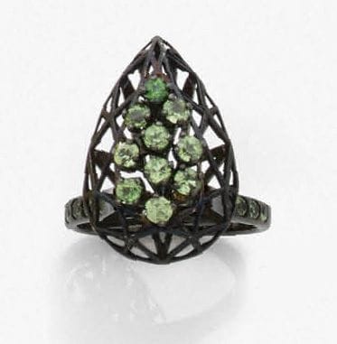Bague en fils d’or 18K (750‰) noirci, le chaton en forme de goutte, complètement ajouré, serti et épaulé de tsavorites.
Travail de Michel Nouïs.
Tour de doigt : 53/54. Poids brut : 6 g