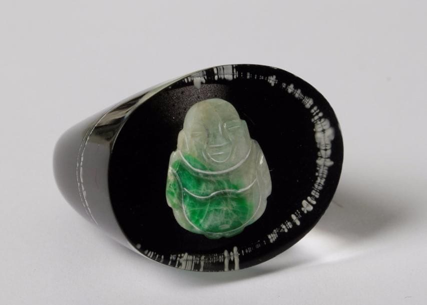 Bague en résine, ornée d’un Bouddha en jade.
Tour de doigt : 54