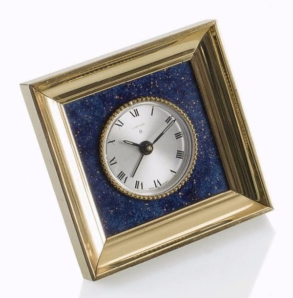 CARTIER
Petit réveil 8 jours de forme carré en métal doré et lapis-lazuli. Cadran argenté, chiffres romains.
Hauteur : 8 cm