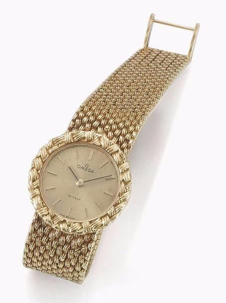 OMéGA
Montre bracelet de dame en or 18K (750‰). Bracelet grain de riz strillé, cadran or avec appliques, aiguilles bâton, cadran légèrement piqué, n° de boîte 131BA7257. Mécanisme Omega calibre 620, fermoir à échelle.
À réviser.
Poids brut : 59,80 g