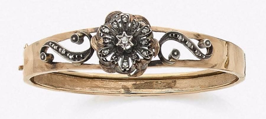 Bracelet en argent et en or 18K (750‰) ajouré, orné d’une fleur stylisée sertie de roses.
Travail français du milieu du XIXe siècle.
Longueur : 17 cm environ.
Poids brut : 13,2 g
(manques, enfoncements)