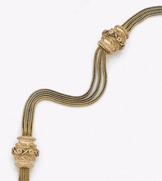 Chaîne de montre en or 18K (750‰) maillons colonne, scandée de deux coulants ornés de motifs fleuris.
Travail français du XIXe siècle.
Longueur : 28,5 cm environ. Poids : 28,7 g