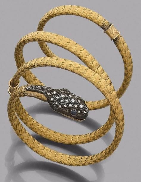 Bracelet armille en or 18K (750‰) tressé formant un serpent, la tête en argent sertie de diamants taillés en roses, les yeux piqués d’un saphir.
Travail français de la fin du XIXe siècle.
Poids brut : 64,5 g
(manque, soudures, déformation)