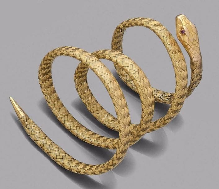 Bracelet armille serpent, les yeux en rubis, la tête et le corps en or 18K (750‰) tressé.
Travail français de la fin du XIXe - début du XXe siècle.
Poids brut : 28 g
(déformations, accident)