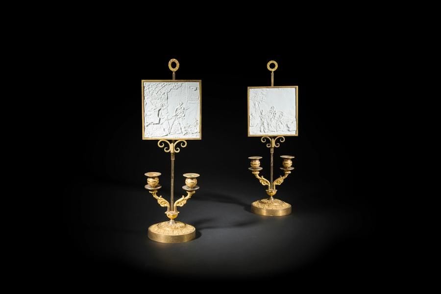 Paire de lampes bouillotte en bronze doré à deux lumières à décor feuillagé reposant sur une base circulaire, le fût à crémaillère à abat-jour à panneau de lithophanie représentant des scènes de l’épopée napoléonienne.
XIXe siècle.
H : 51 cm
Provenant de l’hôtel particulier de Marcel Nahmias, à Boulogne-Billancourt, décoré par Emilio Terry en 1961