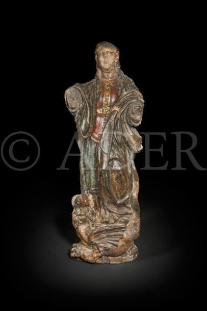 Sainte Marguerite en noyer sculpté en ronde-bosse et polychromé. Debout sur un dragon ailé, la sainte lève les yeux vers le ciel ; elle est vêtue d’une tunique, d’un justaucorps ceinturé et d’un manteau dont un pan revient sur le devant en formant des plis circulaires.
XVIIe siècle
Hauteur : 87 cm
(vermoulures, manques visibles dont les bras, reprises à la polychromie, rebouchage)