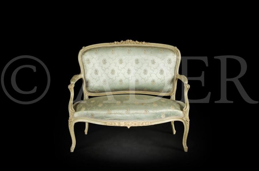 Canapé en bois peint à dossier incurvé, les accotoirs et les pieds mouvementés, sculptés de fleurs et de feuillage.
Style Louis XV.
H : 93 cm, L : 110 cm