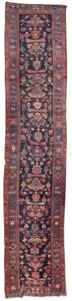 Tapis Karabagh en laine, XXe siècle
Importante galerie du Caucase à décor de motifs stylisés multicolores sur un fond bleu marine. Bordure bleue à fleurs stylisées entourée d’un petit galon rouge.
570 x 125 cm