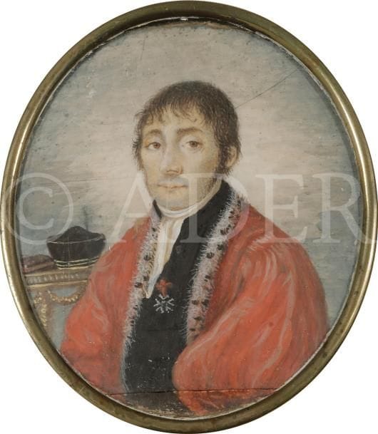 Portrait d’un magistrat, vêtu de son manteau pourpre bordé d’hermine, décoré de la Légion d’honneur, sa coiffe posée sur la table au fond à gauche.
Miniature sur ivoire du XIXe siècle, ovale 7,2 x 6,4 cm (fente au centre) ; joint d’artiste visible en bas.
Cerclé de laiton, avec anneau de suspension, ovale 7,9 x 6,6 cm