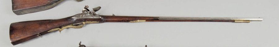 Rare et beau fusil de chasse à vent. Long et fin canon à pans avec cran de mire, gravé au tonnerre. Platine à silex à corps plat, gravée « F. IABOSLER », à corps finement gravé d'une scène de chasse et de rinceaux. Chien col de cygne à corps plat. Superbes garnitures en bronze, à décor de feuillages, chasseur et son chien, cerf attaqué, cerf et biche en sous-bois. Crosse à joue en bois en partie sculpté. Baguette en bois à embout laiton. T.B.E. vers 1740 / 1750. « BOSLER Fredrich Jakob Armurier Fabriquant à DARMASTADT Hesse Allemagne 1717 / 1793 ». Ce fusil a l'apparence d'un fusil traditionnel à silex, seul le trou de lumière n'a pas été fait. Le chien permettait d'armer le système de bombe cachée dans la crosse car les armes à vent étaient interdites