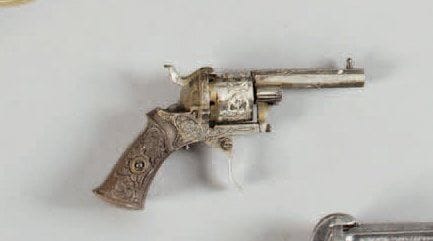 Petit revolver à broche, six coups, calibre 5 mm. Canon à pans. Barillet et carcasse gravés de fleurs. Queue de détente pliante. Plaquettes de crosse en ébonite sculptée. Manque baguette. B.E. Vers 1860. Fabrication Liégeoise. Finition nickelée