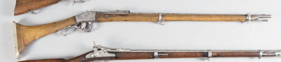 Fusil d'Infanterie Comblain, un coup, calibre 11 mm. Canon rond, rayé, avec hausse, poinçonné « ELG » au tonnerre et matricule. Boitier de culasse « Comblain Breveté » 110574. Garnitures en fer et laiton. Baguette en fer. Monté avec une crosse en noyer, typique des fusils d'Afrique du Nord (moukalah). E.M. Fabrication Belge, vers 1870. (Piqûres)