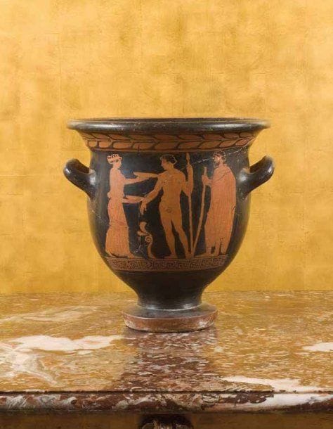 Cratère attribué au peintre de Pisticci. Cratère en cloche à figures rouges peint sur la face A d'une scène représentant le départ d'un jeune guerrier tenant une lance, entre une femme drapée lui tendant des phiales et un homme barbu tenant un bâton. La face B est peinte de trois jeunes hommes drapés en conversation, deux tenant des bâtons. Terre cuite vernissée noir. Cassures et restaurations. Grande Grèce, Lucanie, ca. 430 av. J.-C. Hauteur : 34 cm