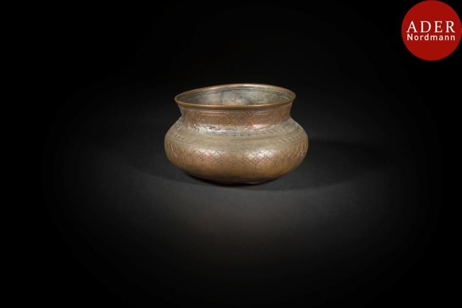 Bassin en laiton, Iran, fin XIXe siècle
A panse globulaire et col évasé, ciselé de registres de médaillons inscrits de poésie persane au col et de motifs floraux à la panse. 
Diam. ouverture : 17,5 cm
État : restaurations au col
A brass bowl, Iran, late 19th century 