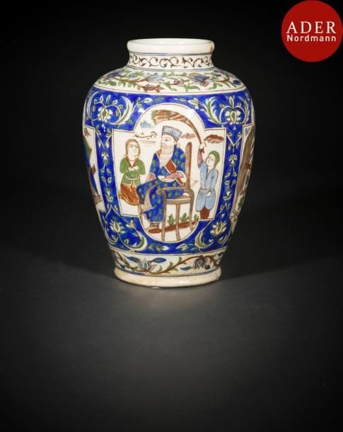 Vase aux personnages, Iran qâjar, XIXe siècle
Vase balustre en céramique peinte en polychromie présentant le roi « Djamshid » trônant et un chasseur dans des médaillons sur fond bleu d’arabesques florales.
Haut. : 33 cm
État : un éclat au col
A Qâjâr pottery vase, Iran, 19th century