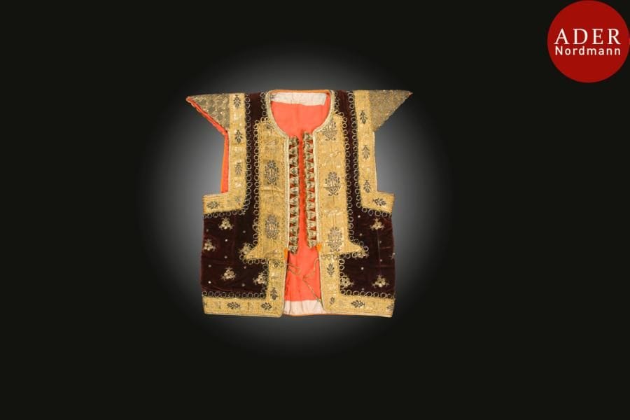 Gilet de mariage, farmla, Tunisie, Nabeul, XXe siècle
Gilet ouvert sans manches, à épaulettes rigides et col rond, en velours brun brodé de fleurs et poissons en fils métalliques et pastilles dorées. Galon métallisé rehaussé de vases fleuris sur le pourtour.
Haut. : 55 cm et largeur avec manches : 55 cm
Bibliographie : Vivier M.F., Noces tissées et Noces brodées, Exposition musée des Arts d’Afrique et d’Océanie, 29 mars au 3 juillet 1995, Paris, p. 96.
A wedding jacket, farmla, Tunisia, Nabeul, 20th century 