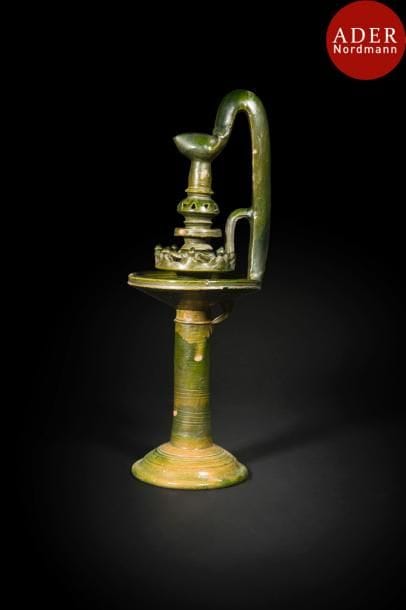 Grande lampe de zawiya, moçbah, Tunisie, XIXe siècle 
Lampe à huile sur haut piédouche en faïence glaçurée vert hyalin et une anse épaisse. 
Haut. : 63 cm
État : éclats de glaçure par endroits 
Bibliographie : Loviconi Alain et Dalila, Faïences de Tunisie, Gignac-la-Nerthe, 1994, p.43.
An oil lamp, mocbah, Tunisia, 19th century