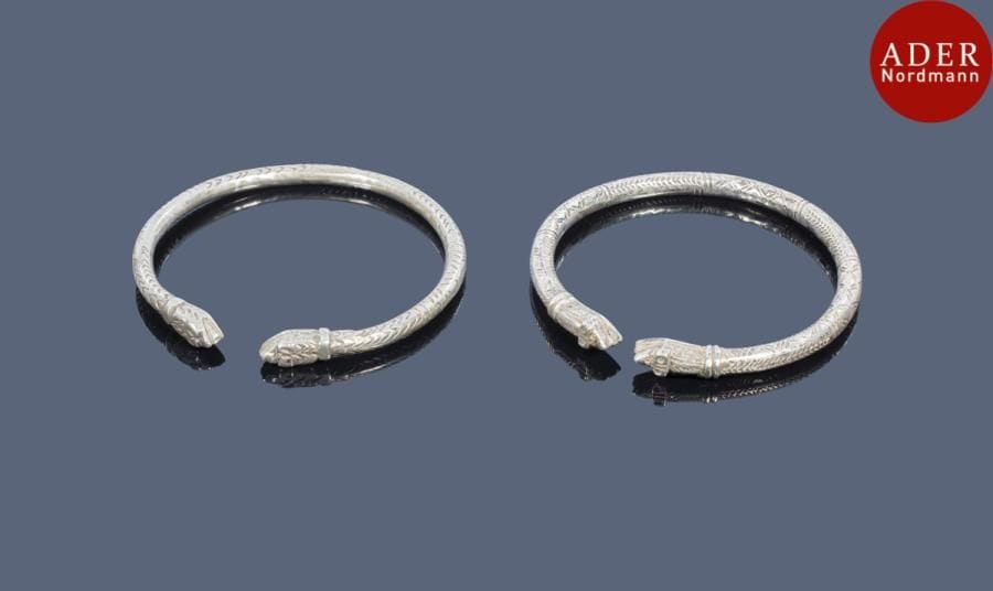 Deux chevillières ardef, en argent bas titre, Algerie, Aures, XXe siècle
Anneaux ouverts ciselés de chevrons et croisillons achevés de tête de serpent ahennashi. Poinçon rectangle ET. 
Diam. : 9.5 cm ; PB : 261 g
Bibliographie : Chakour D., Des trésors à porter, Bijoux et parures du Maroc, Collection de J.-L. et M.-F. Bouvier, I.M.A., Paris, 2016, p.115, n°56.
Two silver-plate anklets, ardef, Algeria,Aurès, 20th century