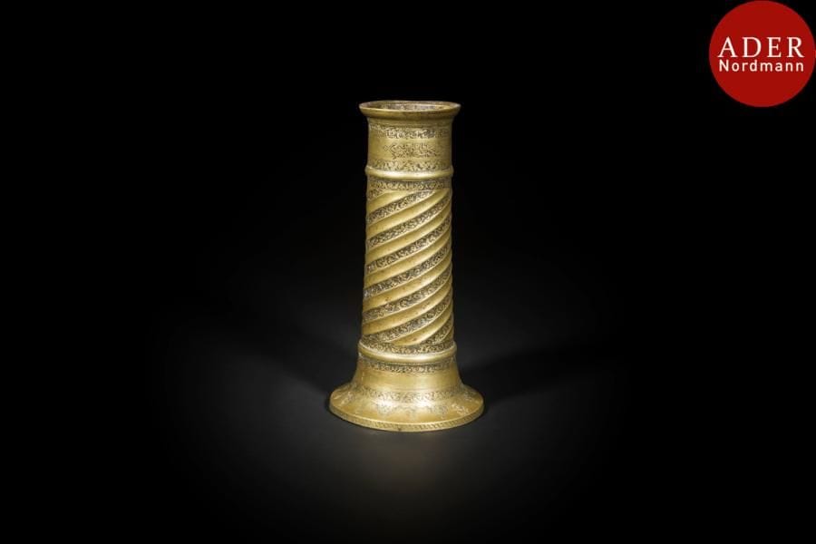 Flambeau, mash’al, Iran safavide, XVIIe siècle
Fût cylindrique scandé de deux bandeaux saillants  sur base évasée en laiton. Décor torsadé, ciselé de rinceaux fleuris sur fond noir. Autour du col, frise deux cartouches inscrits de poésie persane et du nom du propriétaire « Sahibihi Sultan Ali [Hatami] ». 
Haut. : 23 cm
État : manques
A Safavid torch stand, mash’al, Iran 17th century 