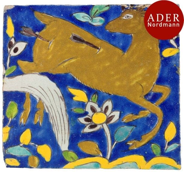 Carreau au cervidé dit à lignes noires, Iran, XVIIe-XVIIIe siècle
Carreau de revêtement à décor polychrome, présentant un cervidé blessé par deux flèches sur un fond bleu fleuri. Pourrait faire partie de la même composition que le lot précèdent 
Dim. : 23,8 x 25,2 cm
État : ébréchures aux bords
A Safavid polychrome pottery tile, Iran, 
17th - 18th century