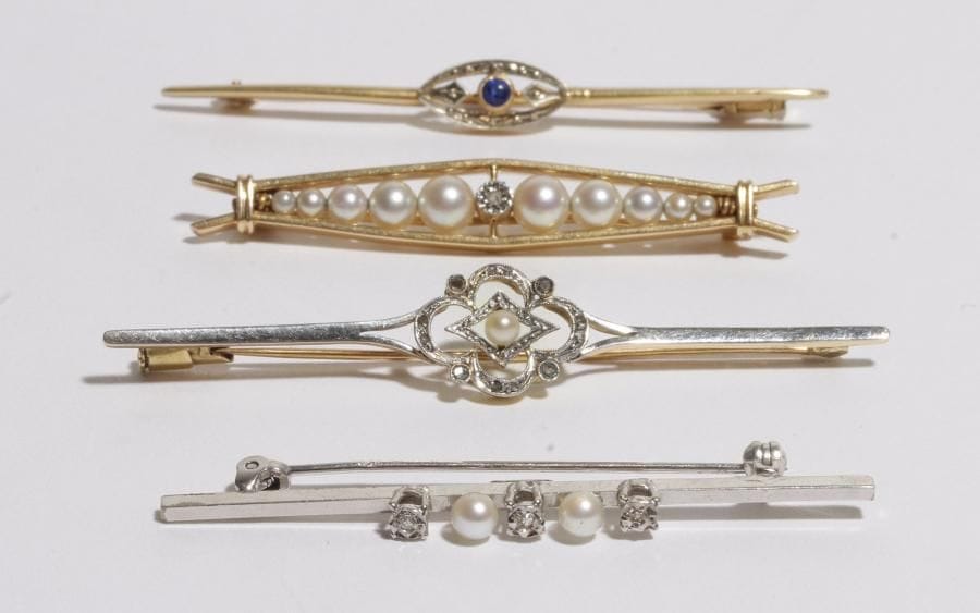 Lot de 3 broches-barrettes en or jaune 18K (750) : la 1ère ornée d'une pierre bleue, les deux suivantes serties de perles de culture et de roses. 
Poids brut : 13,3 g. 
On joint une épingle en or gris 14K (585) sertie de roses et de perles de culture. 
Poids brut : 4,3 g