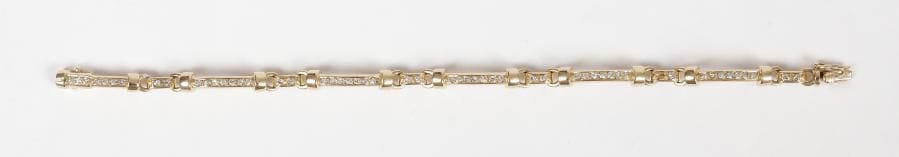 Bracelet en or jaune 18K (750), articulé de maillons allongés sertis de petits diamants alternés d’anneaux agrémentés de diamants. Long. : 18 cm environ. 
Poids brut : 16,4 g (2 manques)