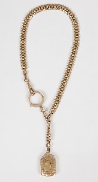Chaîne de montre en or 18K (750) retenant en pendentif un médaillon ouvrant en or 18K. 
Poids brut: 30,2 g