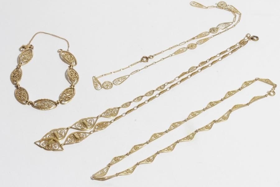 Suite de 3 colliers et un bracelet en or 18K (750) articulés de maillons filigranés. 
Poids : 47,2 g (accident)