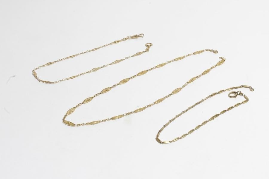 Collier en or 18K (750) articulé de maillons ovales filigranés. 
On joint 2 chaînes de montres en or 18K. 
Poids : 43,1 g