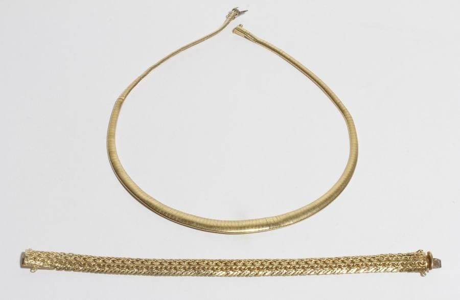 Lot de 2 bijoux en or 18K (750) comprenant : un collier tubogaz plat en chute, un bracelet articulé de maillons géométriques imbriqués. 
Poids : 66,8 g (déformations)