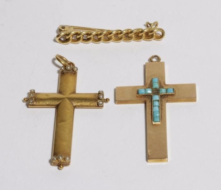 Lot de 3 bijoux en or 18K (750) : deux pendentifs croix dont l'un agrémenté de turquoises, et une petite broche torsadée. 
Poids brut : 5,1 g (manque, enfoncement)
