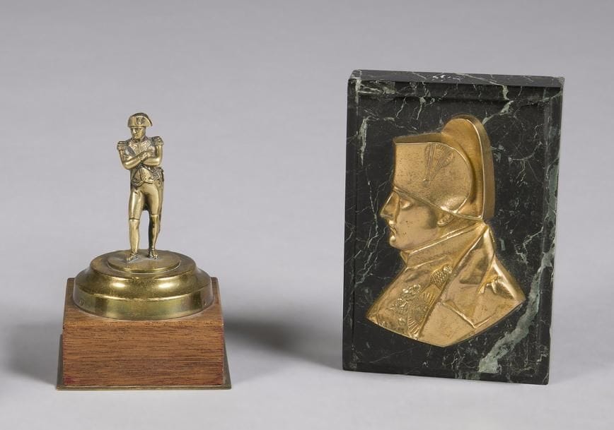 L’Empereur Napoléon Ier: 
- Sujet en pied en laiton sur socle en bois. Hauteur : 12 cm 
- Presse papiers. «L’Empereur «en buste de profil. Bronze doré sur socle en marbre. Hauteur : 12 cm