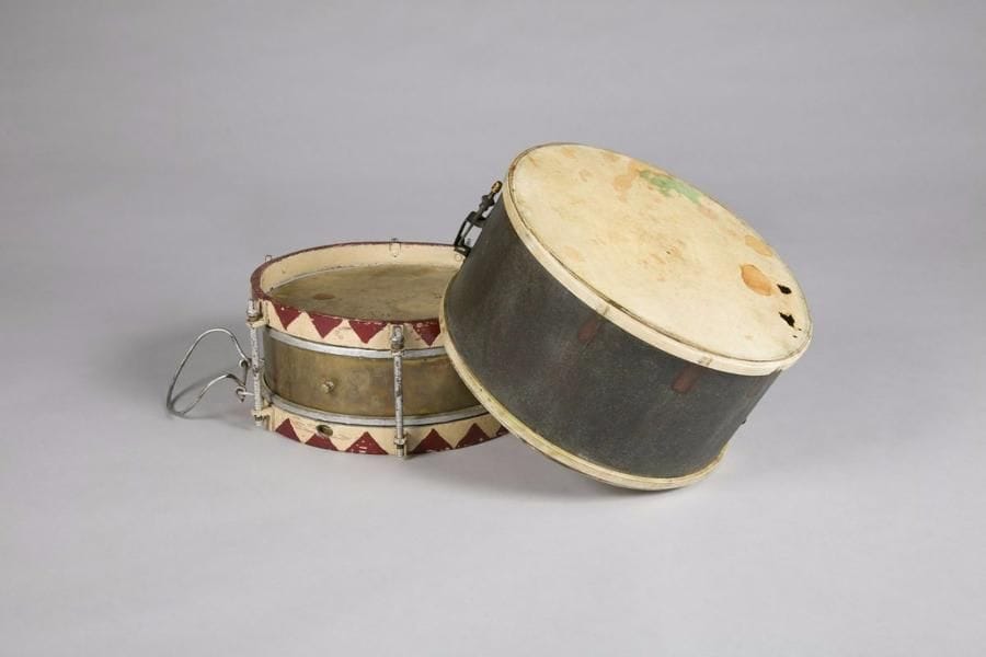 Caisse de tambour allemand. 
Cerclage en bois peint rouge et blanc. Tendeurs peints (manque une peau). On y joint une caisse de tambour en laiton peint. 