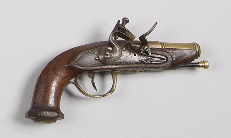 Pistolet de voyage à silex. 
Canon rond à pans au tonnerre, en bronze, tulipé à la bouche. Platine et chien à corps ronds. Garnitures en laiton découpé et gravé. Baguette postérieure. 
B.E. Vers 1780. 