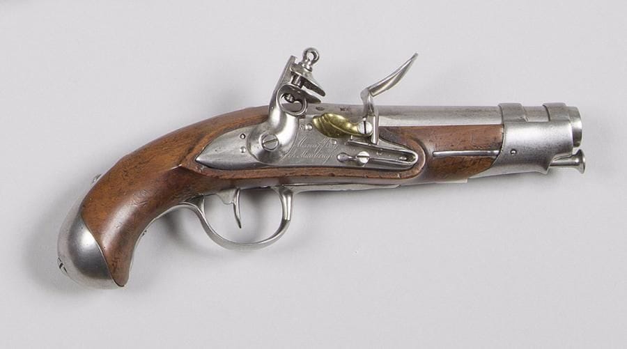 Pistolet de gendarmerie à silex, modèle AN IX.
Canon rond à pans au tonnerre daté 1819 et poinçonné « MR ». Queue de culasse marquée « M.AN 9 ».
Platine signée « Manufre Roy de Maubeuge ». Garnitures en fer poinçonné. 
Crosse en noyer. Baguette en fer. 
T.B.E. 