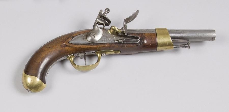 Pistolet d’arçon à silex modèle An XIII. 
Canon rond à pans au tonnerre, queue de culasse marquée « M An 13 ». Platine signée « Maubeuge Manuf Imple ». Garnitures en laiton poinçonné. Crosse en noyer avec restes de marquages. 
A.B.E. (nettoyé). 