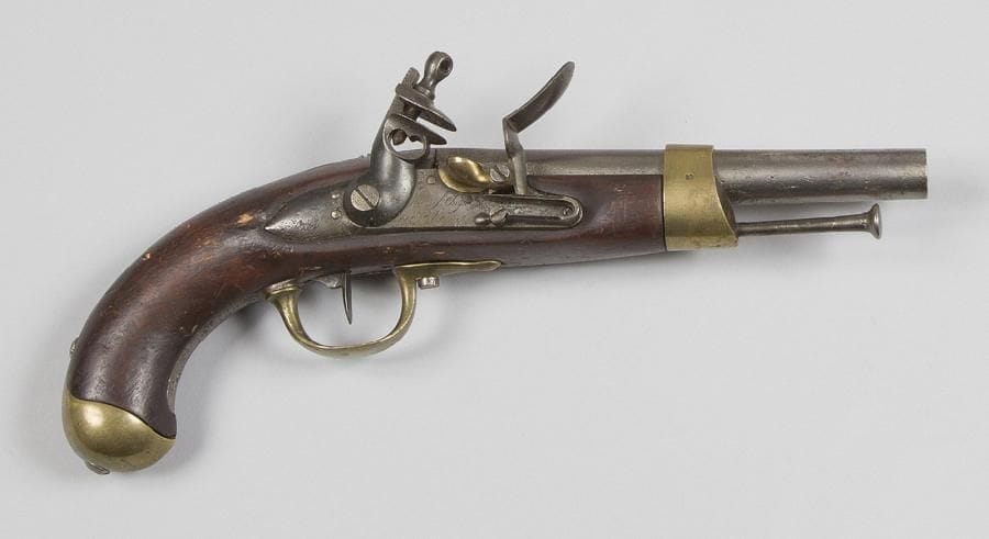 Pistolet d’arçon modèle An XIII.
Canon rond à pans au tonnerre frappé « B 1813 » et poinçonné. Queue de culasse marquée « Mle An 13 ». Platine signée « Manuf Imple de St Etienne ». Garnitures en laiton poinçonné. Baguette en fer.
E.M. (métal peau d’orange).