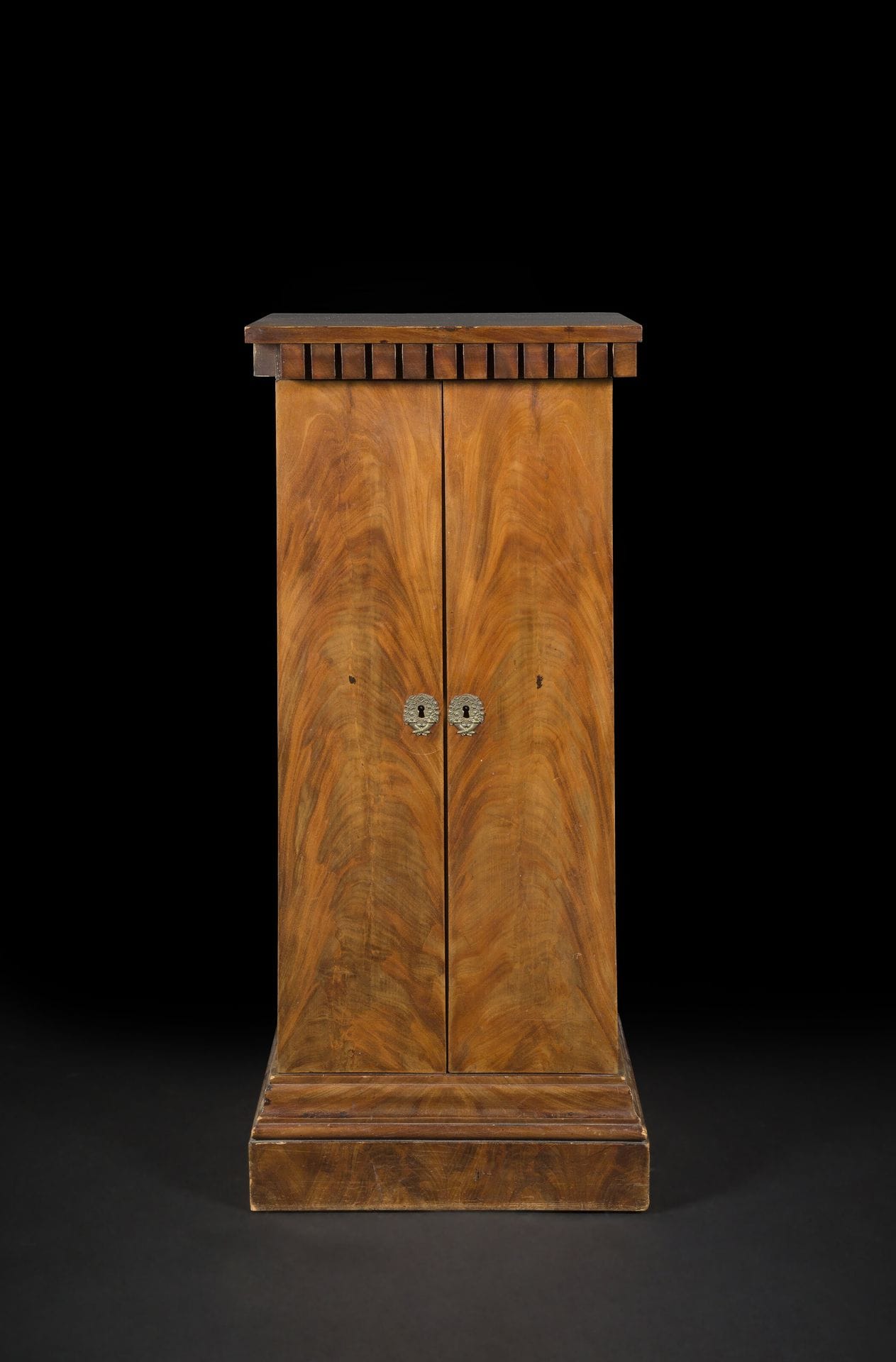 Meuble de rangement en acajou flammé, le plateau à denticules, ouvrant à deux portes découvrant deux tiroirs et deux étagères.
XIXe siècle 
H : 125 cm