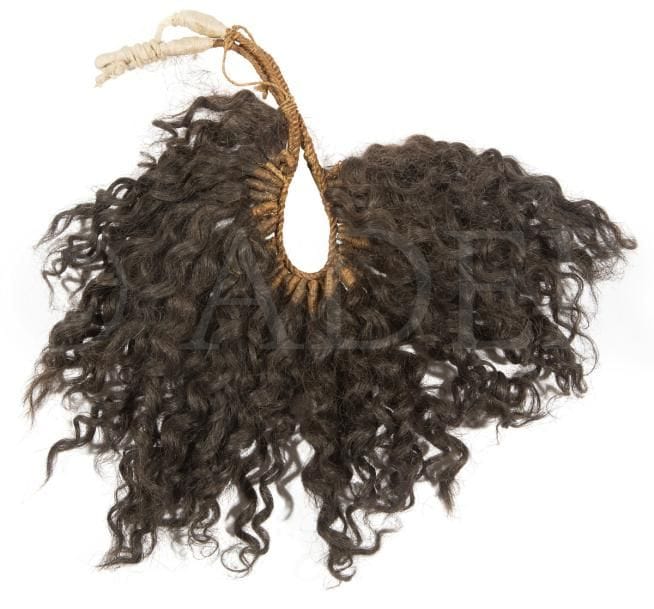 Un bel et ancien ornement masculin, parmi les ornements favoris des hommes marquisiens (titi ovoho et motutu ovoho), attaché vers l’arrière et constitué de cheveux que les hommes pouvaient parfois prélever de la chevelure de leurs épouses. 
Îles Marquises
Cheveux humains, cordelettes de fibres de coco tressées, et autres cordelettes de tapa.
30 x 30 cm environ
Provenance : Collection d’un chasseur-cueilleur magdalénien ou La collection d’un chineur du Lot