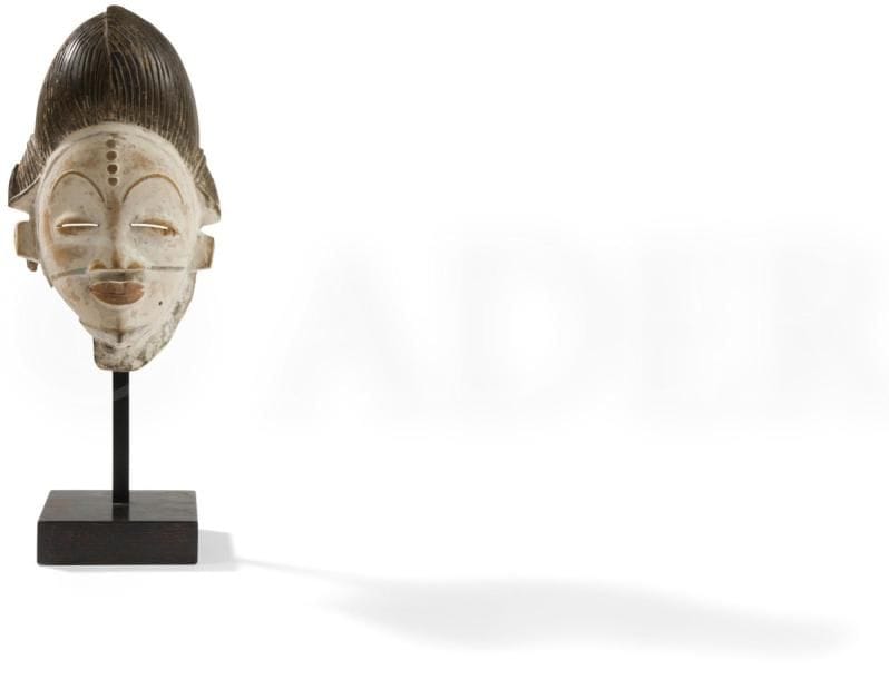 Un très élégant et ancien masque Douma, scarifié de quatre chéloïdes sur le front, à la coiffure à coque en un chignon tressé se chevauchant sur le sommet et deux tresses latérales classiques, les sourcils bien dessinés et tendus, les yeux fendus et la bouche légèrement souriante. Un très bel exemple du genre. 

Tsangui, Gabon

Bois, kaolin, pigment, très belle patine d’usage, accident : manque d’une partie de sa collerette en partie basse à droite (casse ancienne)

H. : 26,5 cm

Provenance : Collection de Madame Godard-Lacroix, Paris