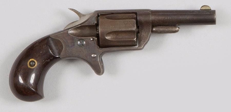 Revolver Colt New line, cinq coups, calibre 30 annulaire.
Canon rond avec patente, marqué « COLT NEW 30 ». Carcasse fermée, détente éperon. Plaquettes de crosse en palissandre (une non vernie).
A.B.E. 