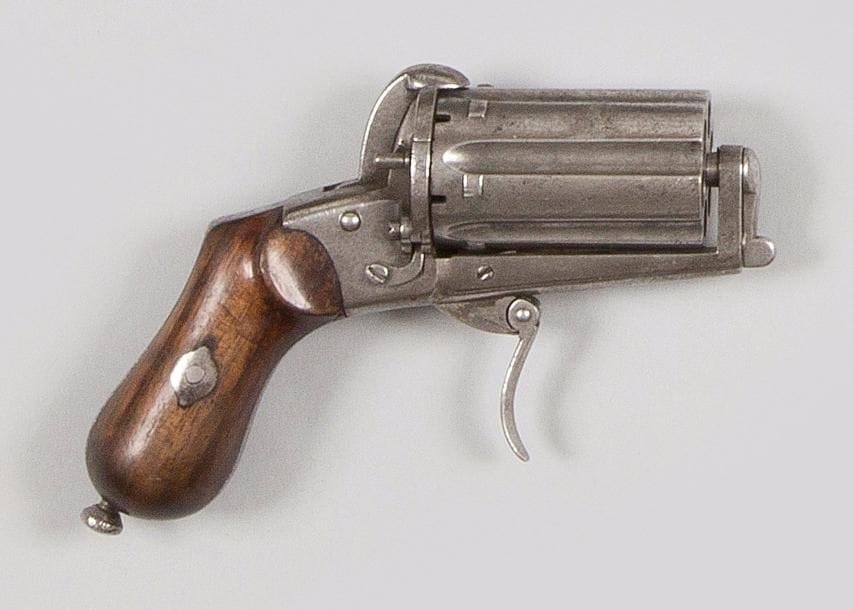 Revolver poivrière à broche, six coups, calibre 7 mm.
Barillet cannelé. Plaquettes de crosses en noyer. Baguette en fer noyée dans la crosse.
A.B.E. (Piqûres) Vers 1870. 
