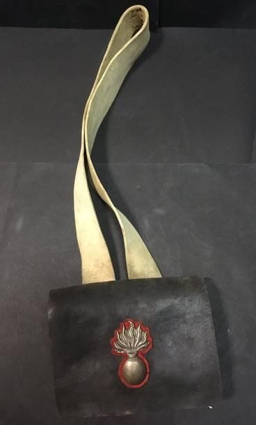 Giberne cartouchière d’infanterie en cuir noir.
Motif à la grenade enflammée en laiton argenté sur fond de drap écarlate découpé en forme. Bretelle, passant et courroies en buffle blanchi.
A.B.E. Époque 1830 / 1848.